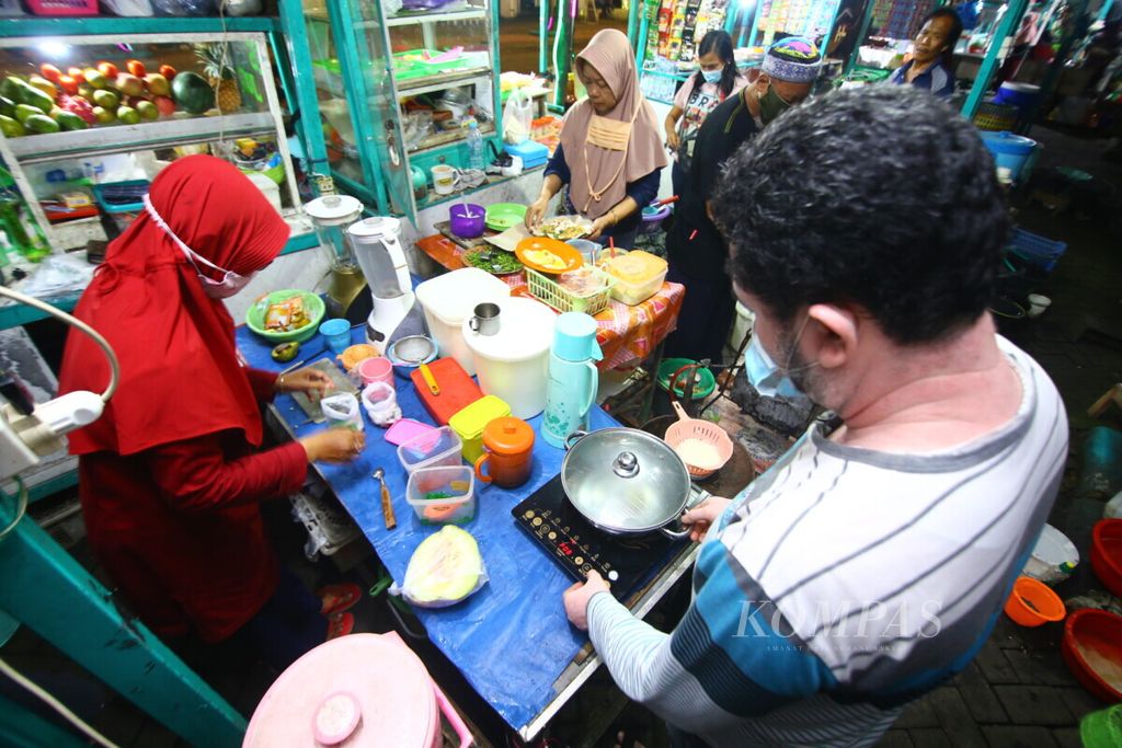 Andi salah seorang pedagang menggunakan kompor induksi untuk berjualan di Kuliner Pintar Taman Blambangan, Banyuwangi, Selasa (24/2/2021).  