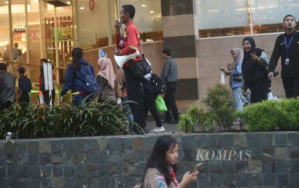 Petugas keamanan memberikan informasi mengenai kondisi yang sudah aman di luar Royal Plaza, Surabaya, pascagempa, Jumat (22/3/2024). 