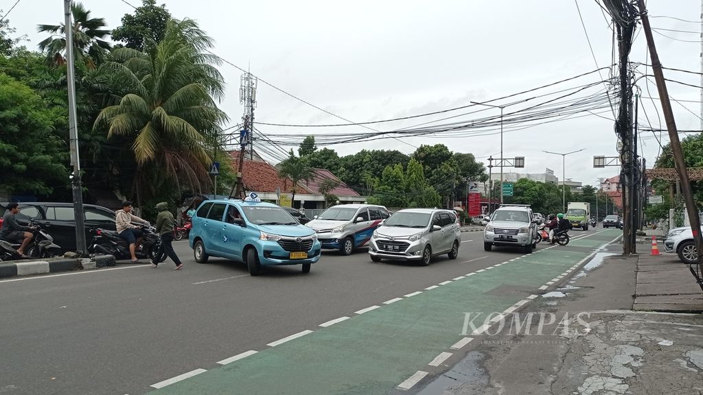 ”Pak ogah” mengatur kendaraan putar balik di Jalan Penjernihan I, Bendungan Hilir, Jakarta Pusat, Minggu (12/2/2023) sore.