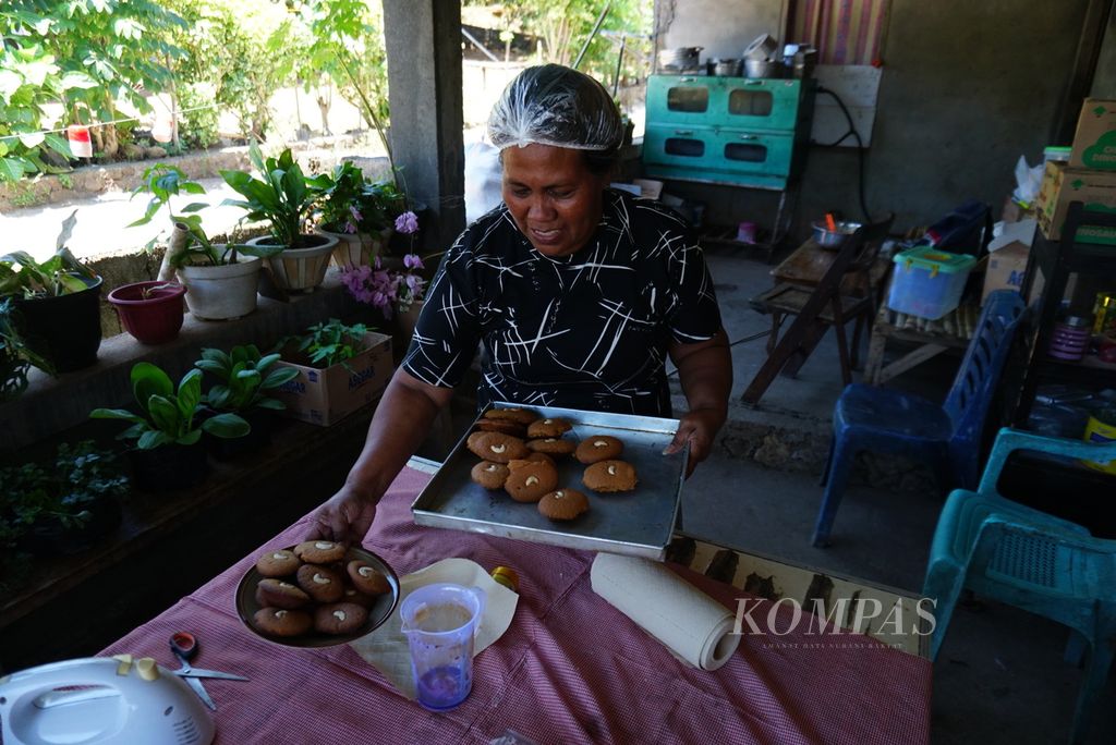 Yeni Alelo (48) membuat kue kolombeng merah di rumahnya yang terletak di Desa Marinsow, Likupang Timur, Minahasa Utara, Sulawesi Utara, Sabtu (16/9/2023). Dengan penghasilan paling sedikit Rp 6 juta per bulan, Yeni berharap pengusaha kue di desa seperti dirinya dapat meningkatkan kesejahteraannya melalui kehadiran Kawasan Ekonomi Khusus (KEK) Likupang.