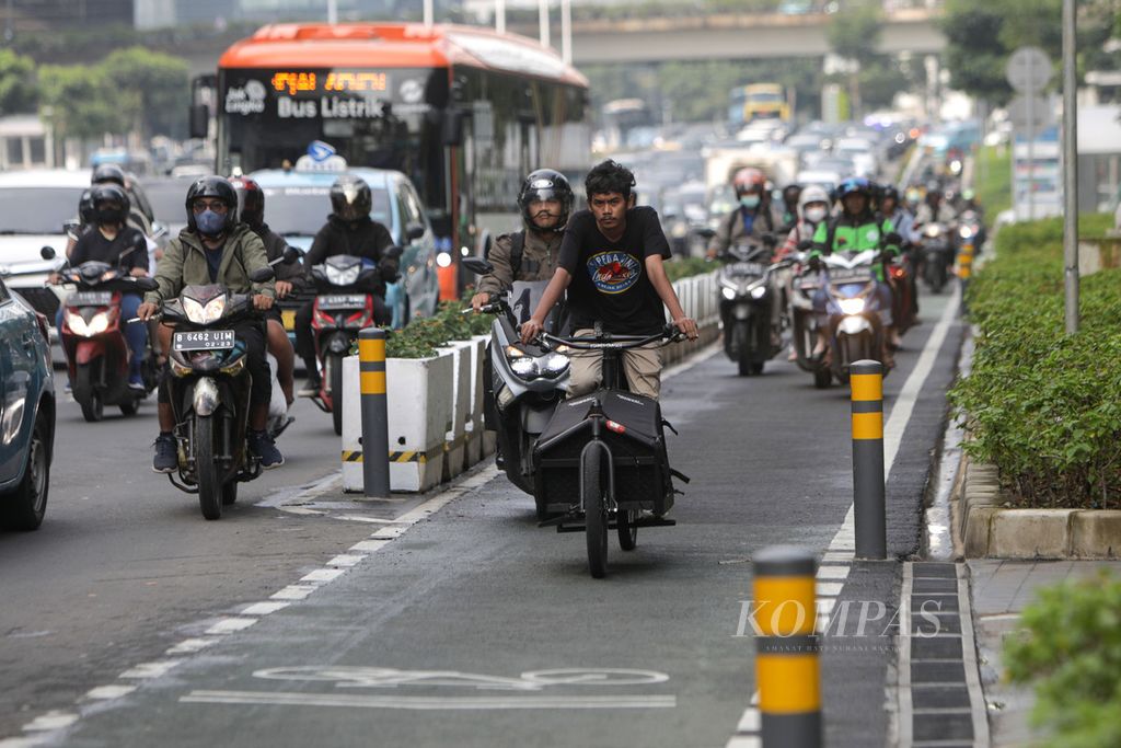 Pesepeda melintas di lajur khusus sepeda di Jalan Jenderal Sudirman, Jakarta, Rabu (21/9/2022). Pemerintah Provinsi DKI Jakarta berencana menambah lajur sepeda pada 2022 ini sepanjang 196,45 kilometer. Lajur sepeda tersebut tersebar di 26 ruas jalan. Lajur sepeda yang dibangun terdiri atas lajur terproteksi atau dibatasi dengan <i>stick cone</i> sepanjang 40,06 km. Kemudian lajur berbagi ditandai dengan marka atau paku jalan (<i>share</i>) sepanjang 154,73 km serta lajur sepeda di trotoar sepanjang 1,67 km. 