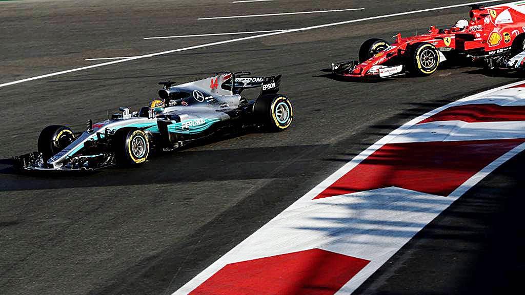 Pebalap  Inggris, Lewis Hamilton, memacu mobil  Mercedes F1 WO8 di depan pebalap Jerman, Sebastian Vettel, yang mengendarai mobil  Ferrari SF70H pada balapan F1  di Sirkuit Baku, Minggu (25/6). Balapan itu diwarnai insiden Vettel yang menabrakkan ban mobilnya ke ban mobil Hamilton.  