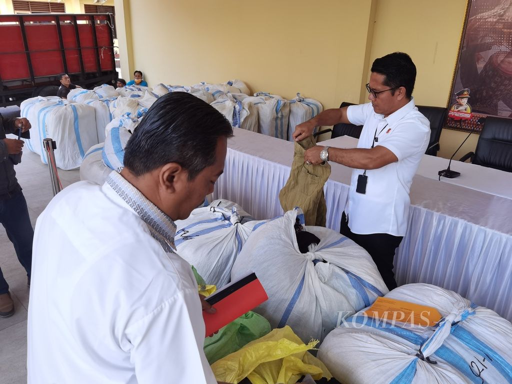 Anggota Kepolisian Daerah Nusa Tenggara Barat mengeluarkan barang bukti pakaian bekas impor yang berhasil disita dari seorang pedagang di Kota Mataram, Selasa (4/4/2023). Pakaian bekas itu diduga dikirim dari Bali untuk dijual di NTB.