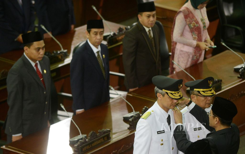 Menteri Dalam Negeri Gamawan Fauzi menyematkan tanda kepangkatan saat melantik Ganjar Pranowo (kiri) dan Heru Sudjatmoko sebagai Gubernur Jawa Tengah beserta wakilnya di Gedung Paripurna DPRD Jawa Tengah, Kota Semarang, Jumat (23/8/2013). 