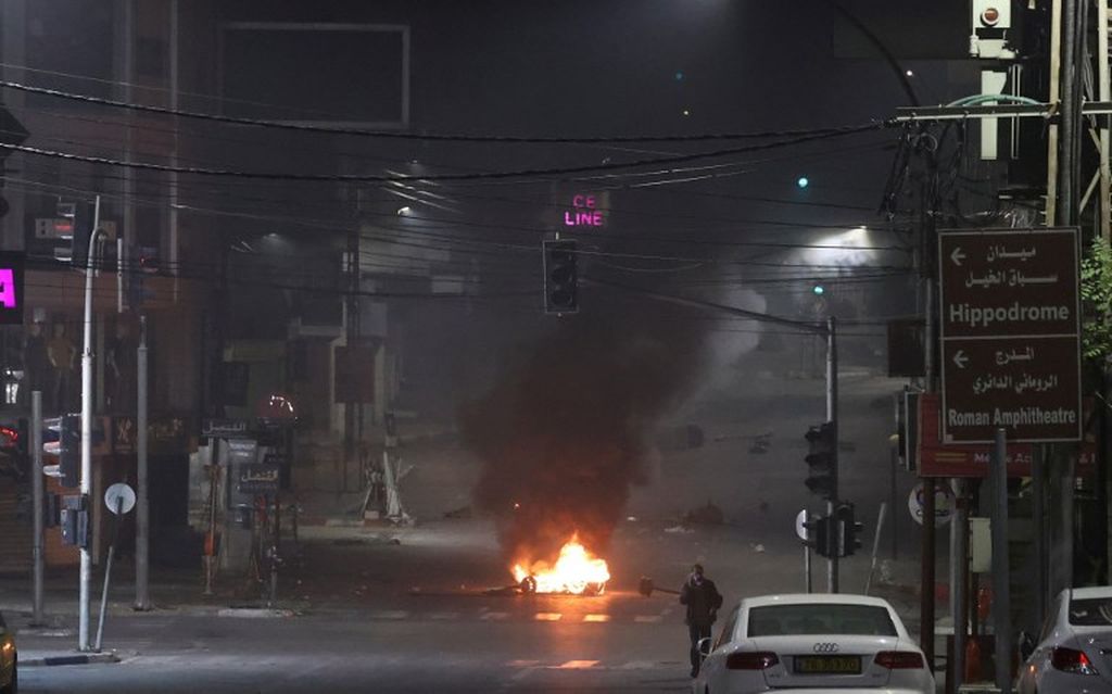 Pengunjuk rasa membakar ban di jalan-jalan kota Nablus dalam bentrokan dengan pasukan Israel di Nablus, wilayah pendudukan Tepi Barat, Selasa (25/10/2022). 