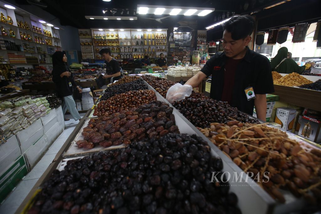 Pegawai toko oleh-oleh haji dan umrah memilih buah kurma pesanan pelanggan di kawasan Tanah Abang, Jakarta, Jumat (15/3/2024).