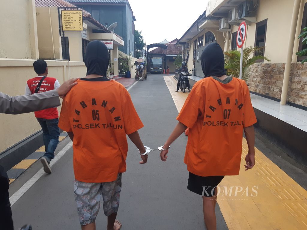 Dua tersangka yang masih berstatus pelajar berjalan dengan tangan terborgol di Polresta Cirebon, Kabupaten Cirebon, Jawa Barat, Jumat (6/1/2023). Keduanya menjadi tersangka kasus penganiayaan yang menewaskan seorang anak.