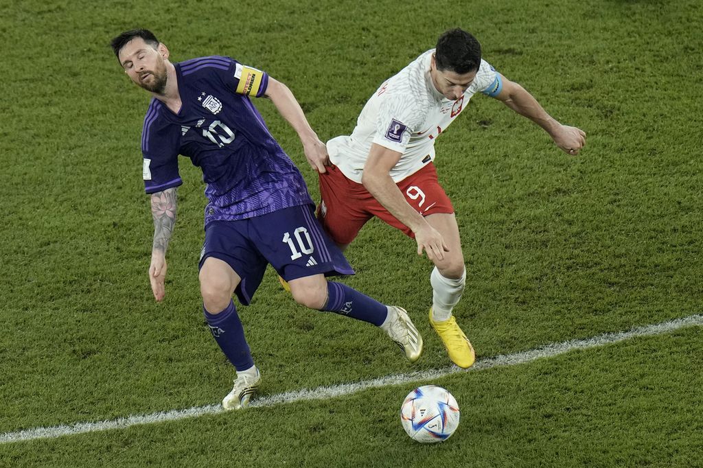 Penyerang Argentina Lionel Messi (kiri) dan penyerang Polandia Robert Lewandowski berduel dalam perebutan bola dalam laga terakhir Grup C di Stadion 974, Doha, Qatar, Kamis (1/12/2022) dini hari WIB. Argentina menang atas Polandia 2-0.