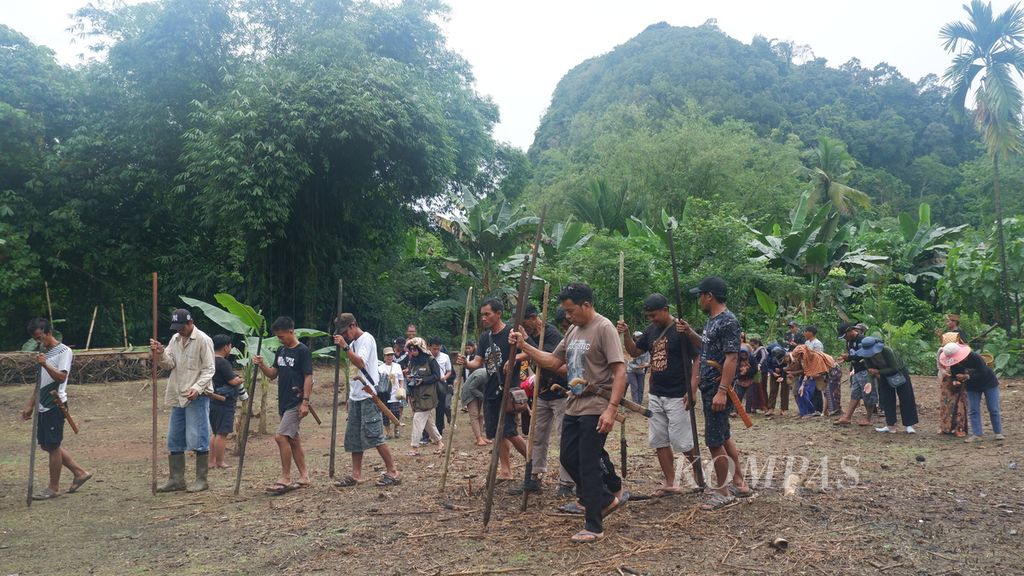 Warga Dayak Deah menugal atau menanam padi (<i>ngasok miah</i>) di ladang pada Festival Melatu Wini 2023 di Desa Liyu, Kecamatan Halong, Kabupaten Balangan, Kalimantan Selatan, Sabtu (2/12/2023).