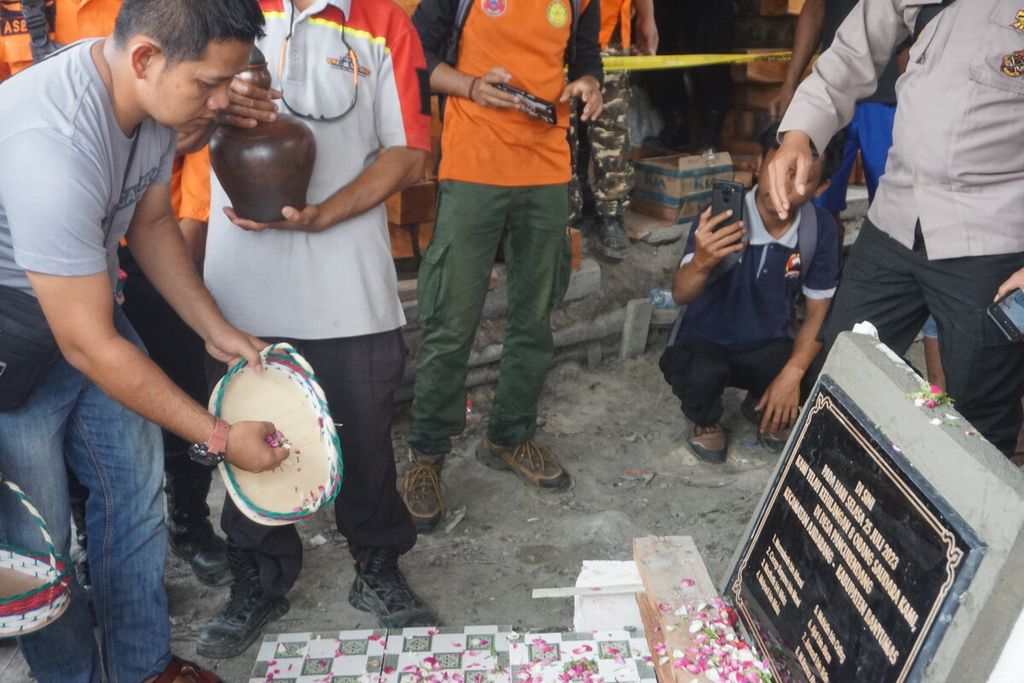 Keluarga korban menaburkan bunga di prasasti nama-nama delapan petambang emas yang hilang di Desa Pancurendang, Ajibarang, Banyumas, Jawa Tengah, Selasa (1/8/2023).