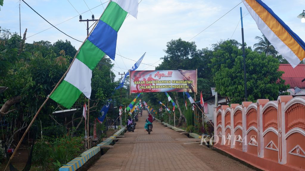 Warga melewati jalan perkampungan di Desa Benua Riam, Kecamatan Aranio, Kabupaten Banjar, Kalimantan Selatan, Jumat (27/5/2022). Benua Riam merupakan salah satu desa terisolasi karena akses utamanya masih melalui Waduk Riam Kanan.