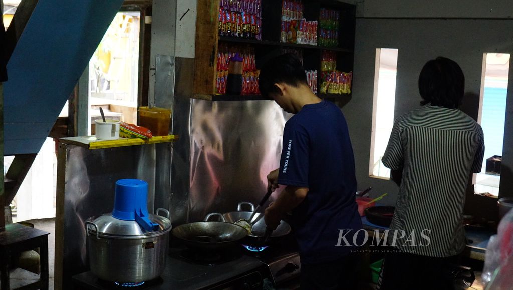 Pelayan sedang menyiapkan makanan bagi pelanggannya di Warung Burjo Samiasih, Desa Caturtunggal, Kecamatan Depok, Kabupaten Sleman, Daerah Istimewa Yogyakarta (DIY), Selasa (18/10/2022). 