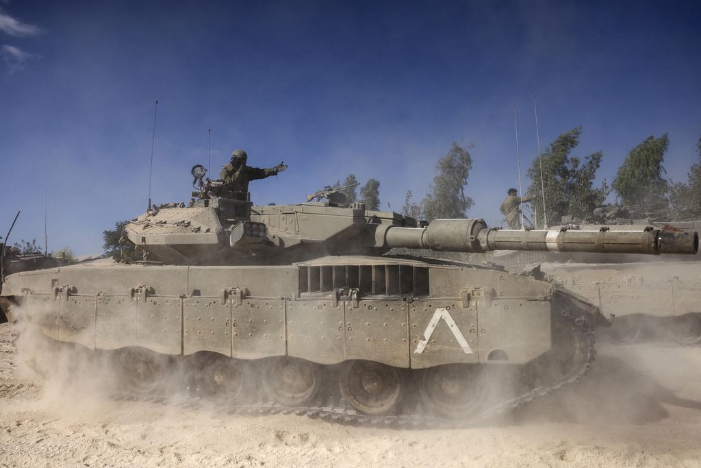 Seorang tentara Israel meneriakkan instruksi dari atas tank Merkava di luar Kibbutz Beeri dekat perbatasan dengan Jalur Gaza, 20 Oktober 2023. 