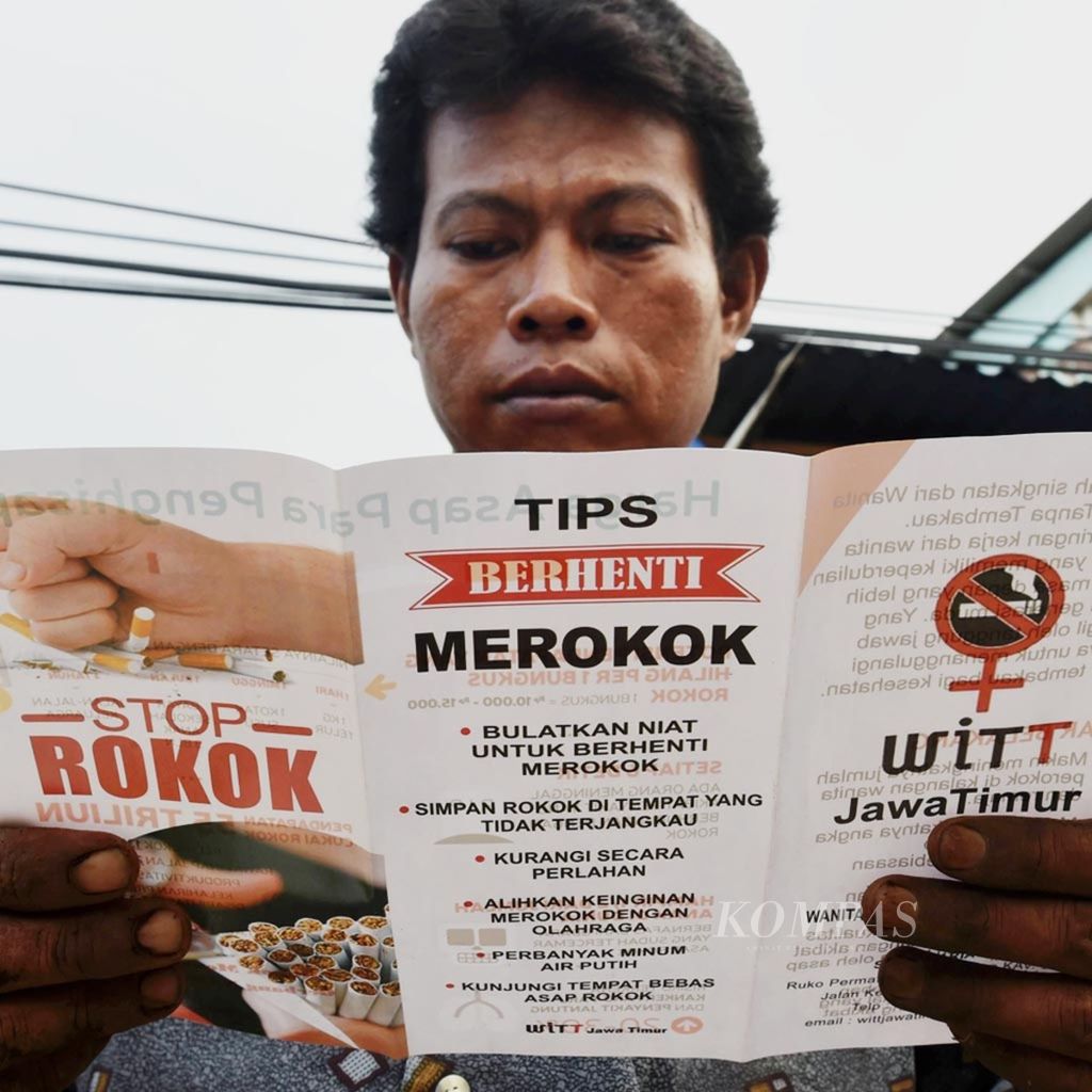 Pedagang membaca brosur yang dibagikan sukarelawan Wanita Indonesia Tanpa Tembakau Jawa Timur pada peringatan Hari Anti Tembakau Sedunia di Pasar Keputran, Surabaya, 2016. 
