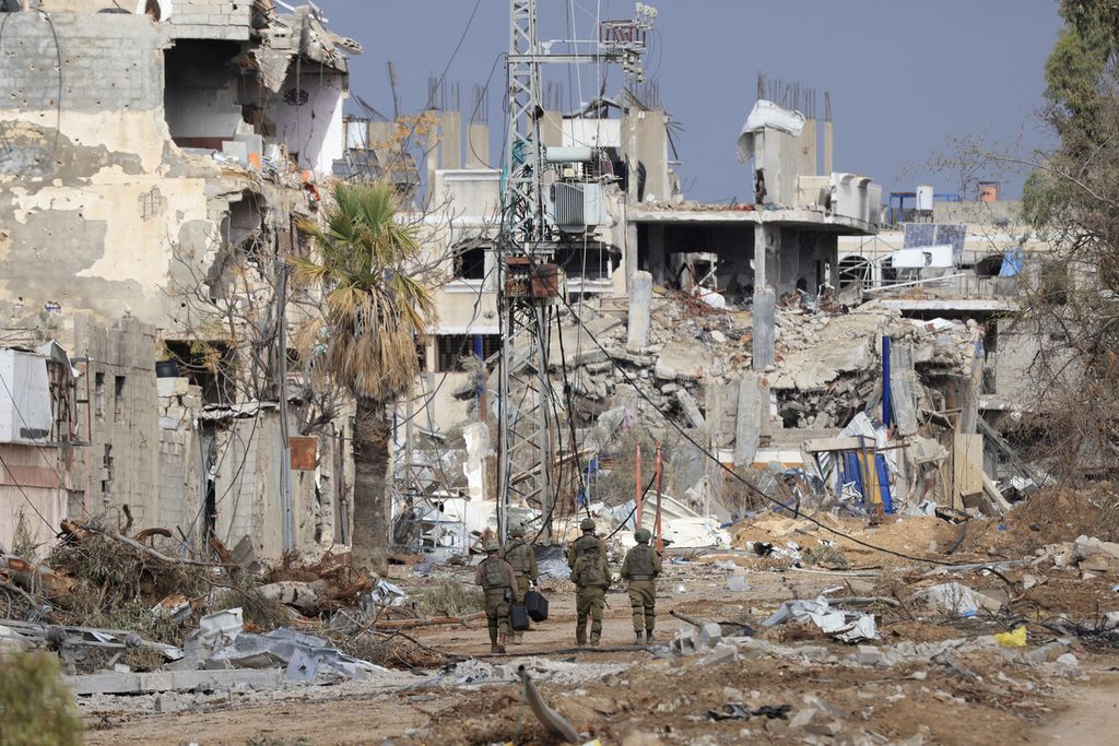 Pasukan Israel berjalan melewati bangunan yang hancur di sepanjang Jalan Salaheddine, yang menghubungkan Jalur Gaza utara dengan selatan di Distrik Zeitoun, kota Gaza, 28 November 2023. 