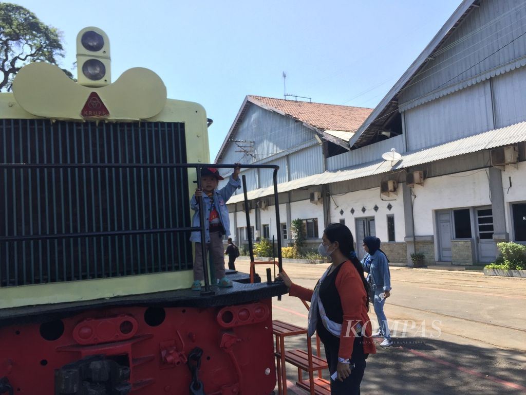 Pengunjung berfoto di lokomotif kuno buatan Krupp, Jerman, saat gelar griya (<i>open house</i>) di Balai Yasa Surabaya Gubeng, Jawa Timur, Minggu (25/9/2022).