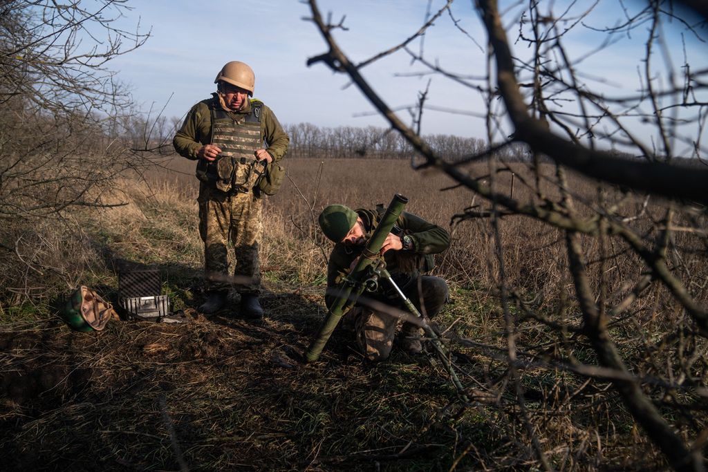 Dua anggota pasukan Ukraina tengah mempersiapkan meluncurkan mortar ke posisi militer Rusia di di sebuah lokasi di Bakhmut, wilayah Donetsk, Ukraina, Jumat (9/12/2022). Militer Rusia melancarkan serangan ke wilayah ini dan mencoba untuk mengontrolnya setelah mereka kehilangan kendali atas Kherson. 