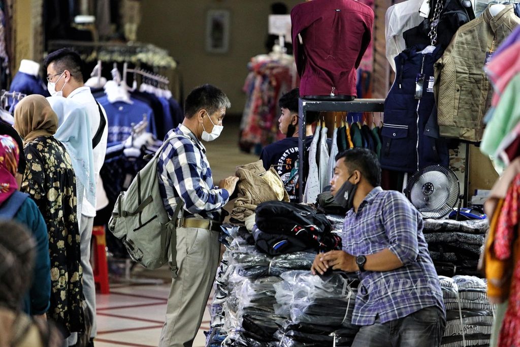 Pedagang pakaian di Pasar Tanah Abang, Jakarta, melayani warga yang hendak berbelanja, Jumat (13/5/2022). 