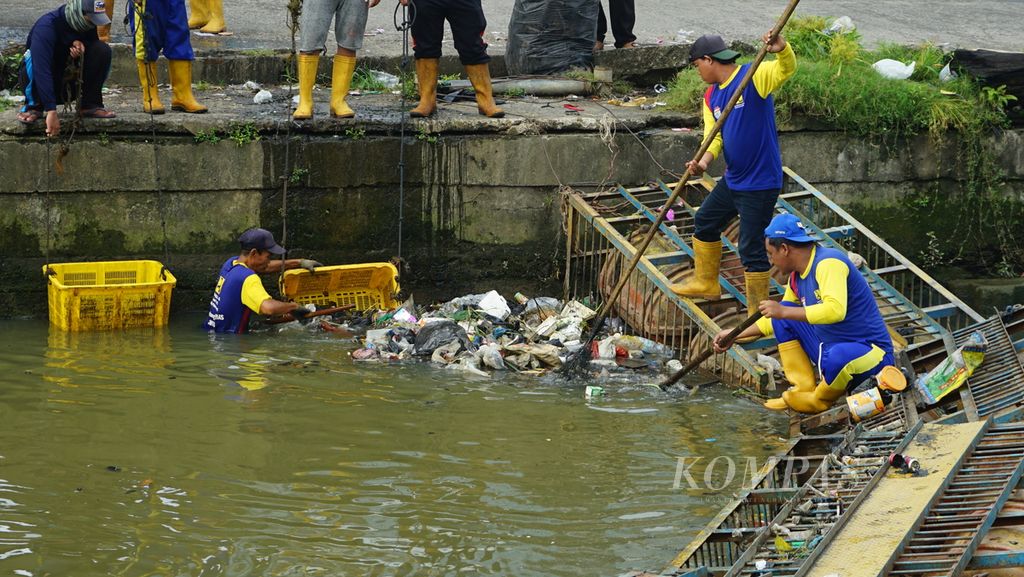 Petugas Dinas Pekerjaan Umum dan Penataan Ruang Kota Palembang membersihkan aliran Sungai Bendung di Palembang, Sumsel, Selasa (24/5/2022).
