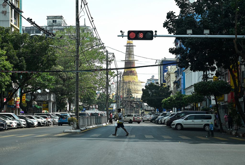 Seorang pria menyeberangi jalan yang nyaris kosong saat mogok sunyi untuk memprotes dan memperingati dua tahun kudeta militer Myanmar di Yangon, Myanmar, 1 Februari 2023. 