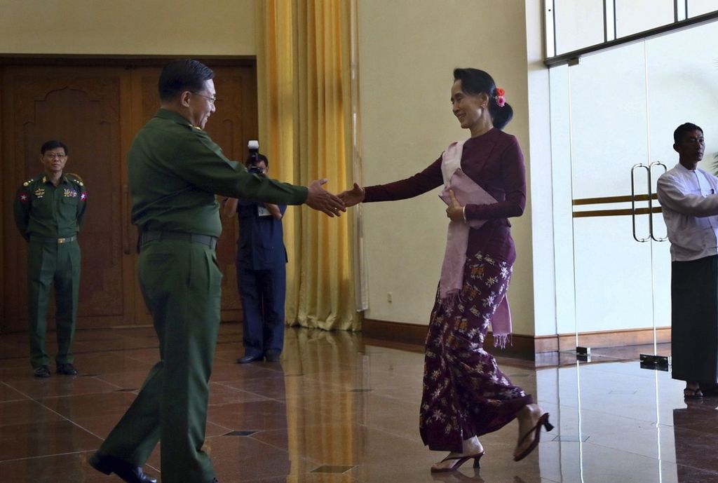 Dalam foto bertanggal 2 Desember 2015, Panglima Angkatan Bersenjata Myanmar Jenderal Senior Min Aung Hlaing (kiri) menyambut kedatangan Aung San Suu Kyi dalam pertemuan di Naypyidaw, Myanmar.