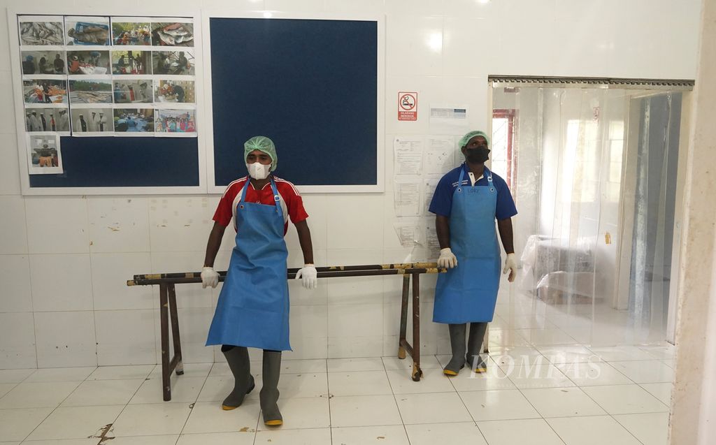 Pekerja koperasi, Syamsudin (kiri) dan Donatus, seusai mengemas potongan ikan tangkapan nelayan Kamoro di pabrik pengolahan ikan milik Koperasi Maria Bintang Laut (KMBL), Timika, Papua, Kamis (17/3/2022).