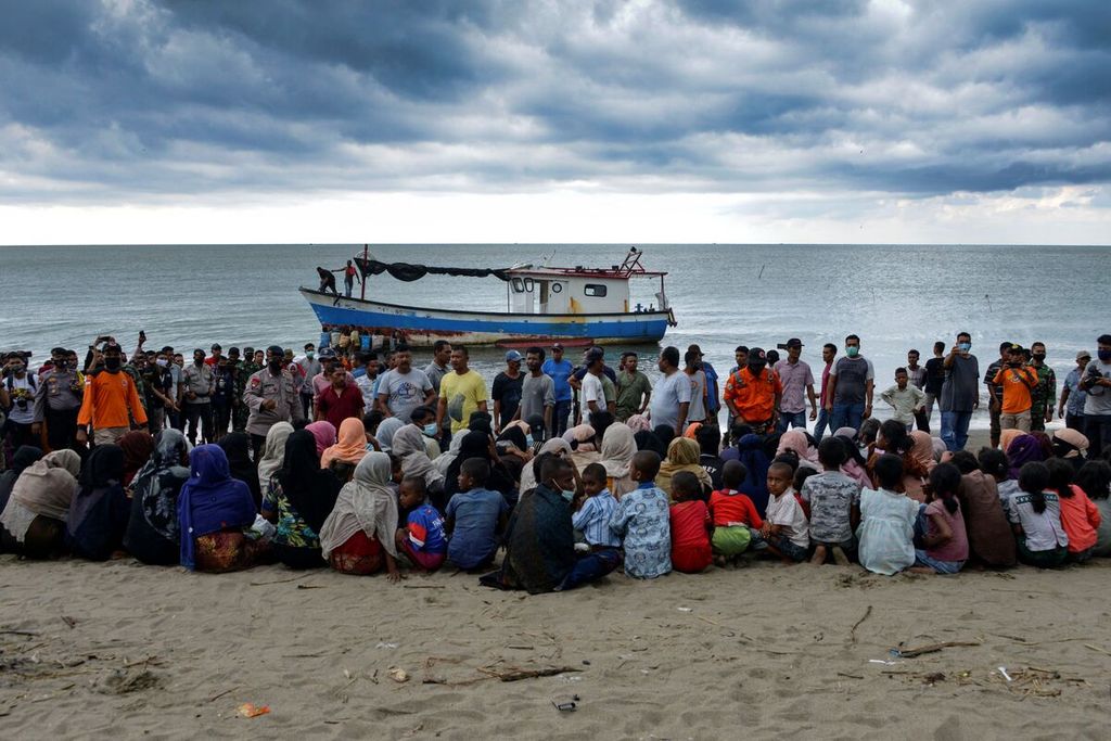 Dalam arsip foto yang diambil pada 25 Juni 2020 ini, warga Rohingya yang dievakuasi dari Myanmar duduk di pesisir Desa Lancok di Kabupaten Aceh Utara, Aceh, setelah sekitar 100 warga, termasuk 30 anak, diselamatkan dari perahu kayu di lepas pantai Sumatera. 