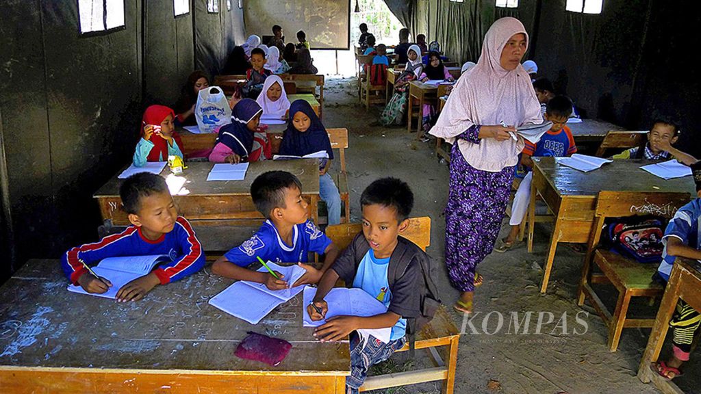 Anak-anak belajar di tenda yang didirikan di halaman SD Negeri Bantarpanjang, Desa Bantarpanjang, Kecamatan Cikeusal, Kabupaten Serang, Banten, Kamis (26/10/2017). Sekolah itu rusak berat sehingga warga bersama polisi secara swadaya mendirikan tenda agar anak-anak bisa tetap belajar. 