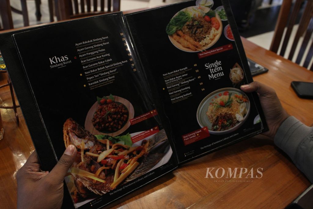 Pengunjung mengamati menu di restoran khas Sunda Sindang Reret, Kota Bandung, Jawa Barat, Rabu (27/12/2023).
