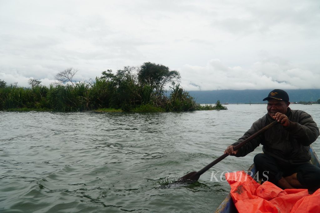 Warga bersampan meninggalkan pulau terapung seluas lebih dari 1 hektar yang hanyut di Danau Kerinci di perairan Desa Seleman, Kecamatan Danau Kerinci, Kabupaten Kerinci, Jambi, Jumat (19/1/2024).
