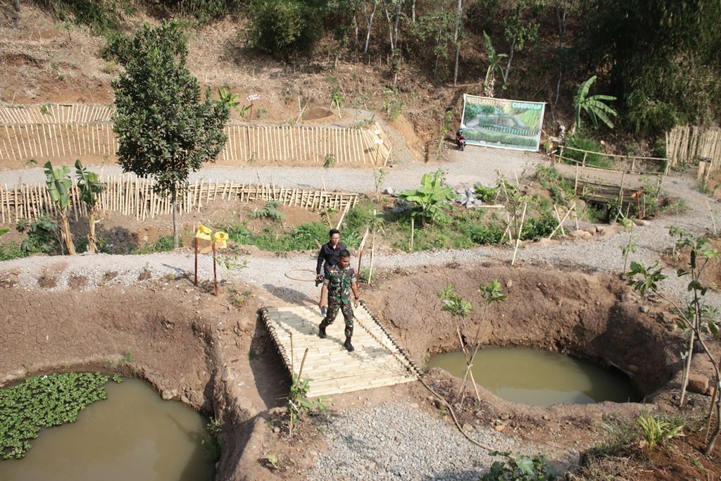 Petugas melintasi dua kolam di Wetland (taman rawa) Cisurupan, Kecamatan Cibiru, Kota Bandung, Senin (23/9/2019). Kawasan ini terdiri atas 18 kolam dengan daya tampung total 5.000 meter kubik dari aliran Sungai Ciloa yang mengalir ke arah Bandung Timur.