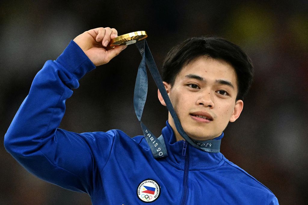 Carlos Edriel Yulo berpose dengan medali emas yang disabetnya di ajang Olimpiade Paris 2024 di Bercy Arena Paris, Perancis, Sabtu  (3/8/2024). 