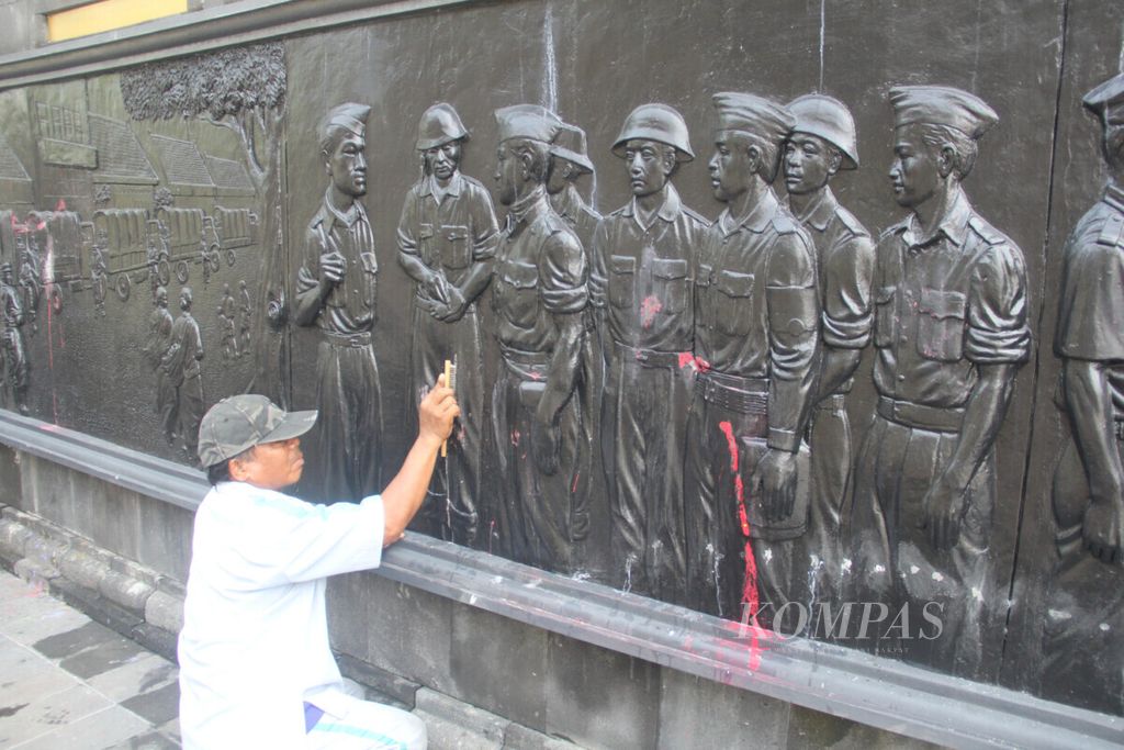 Petugas Museum Benteng Vredeburg membersihkan coretan yang ada di relief Monumen Serangan Umum 1 Maret 1949, Kota Yogyakarta, Rabu (20/2/2019).