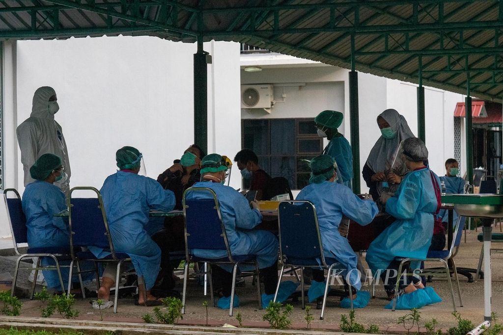 Petugas kesehatan memeriksa sejumlah pasien Covid-19 yang baru tiba di lokasi karantina terpadu Asrama Haji Kota Batam, Kepulauan Riau, Jumat (11/6/2021).