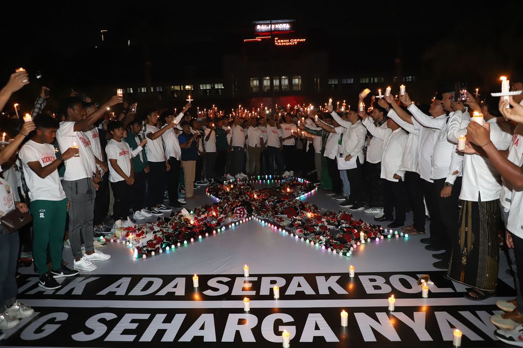 Warga yang hadir pada acara doa bersama untuk korban tragedi Kanjuruhan, di Taman Surya, Surabaya, Jawa Timur, Selasa (4/10/2022) malam, menyalakan lilin sebagai tanda cinta perdamaian.