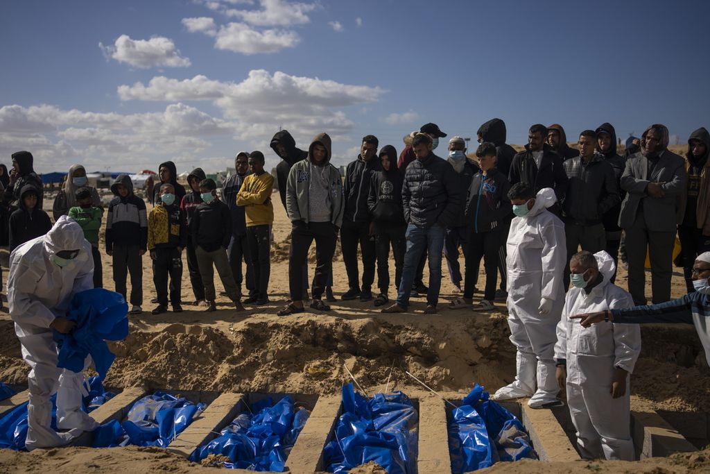 Warga Palestina menguburkan jenazah warga yang terbunuh akibat serangan Israel dan dikembalikan ke Gaza olrh militer Israel dalam pemakaman massal di Rafah, Jalur Gaza, 30 Januari 2024. 