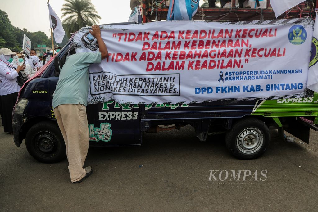 A banner containing the participants' complaints was installed on the command vehicle in the Arjuna Wiwaha Horse Statue area, Jakarta, on Monday (7/8/2023). Hundreds of honorary health workers who are members of the Honorary Communication Forum of Health Workers and Non-Health Workers staged a demonstration demanding that the government issue special regulations to appoint honorary workers as civil servants.