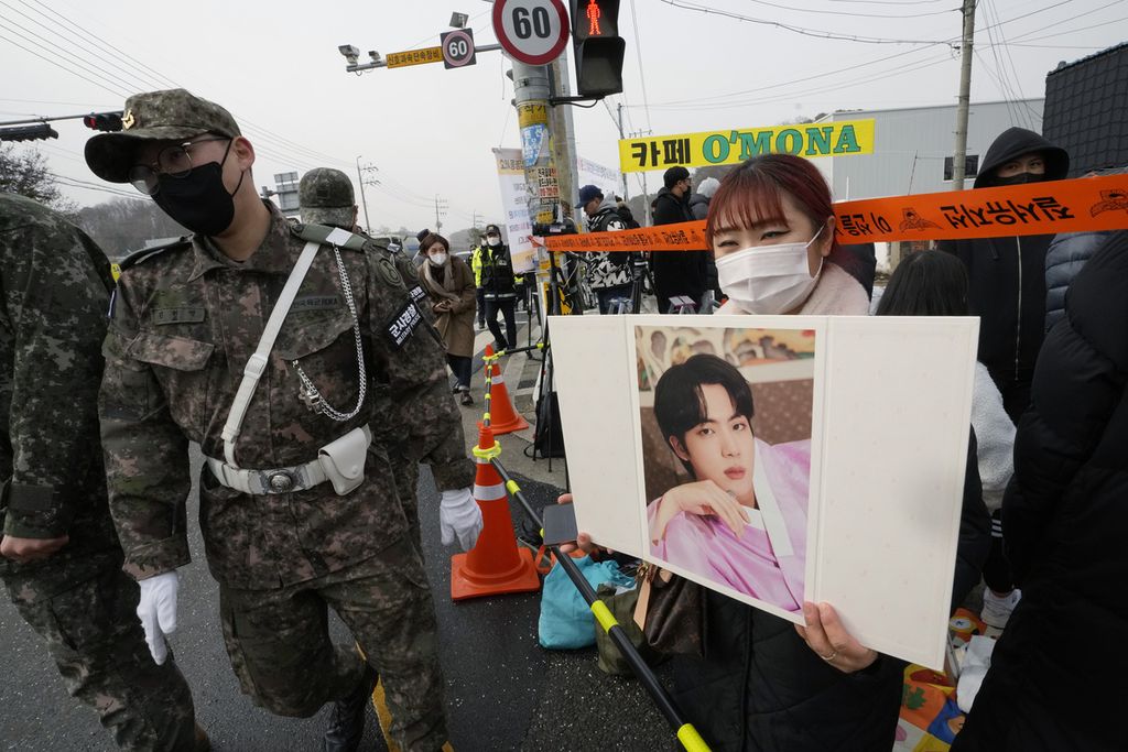 Seorang penggemar BTS menunggu kedatangan anggota K-pop, BTS, Jin,di kamp latihan militer tempat Jin akan menjalani wajib militer di Yeoncheon, Korea Selatan, Selasa (13/12/2022).  