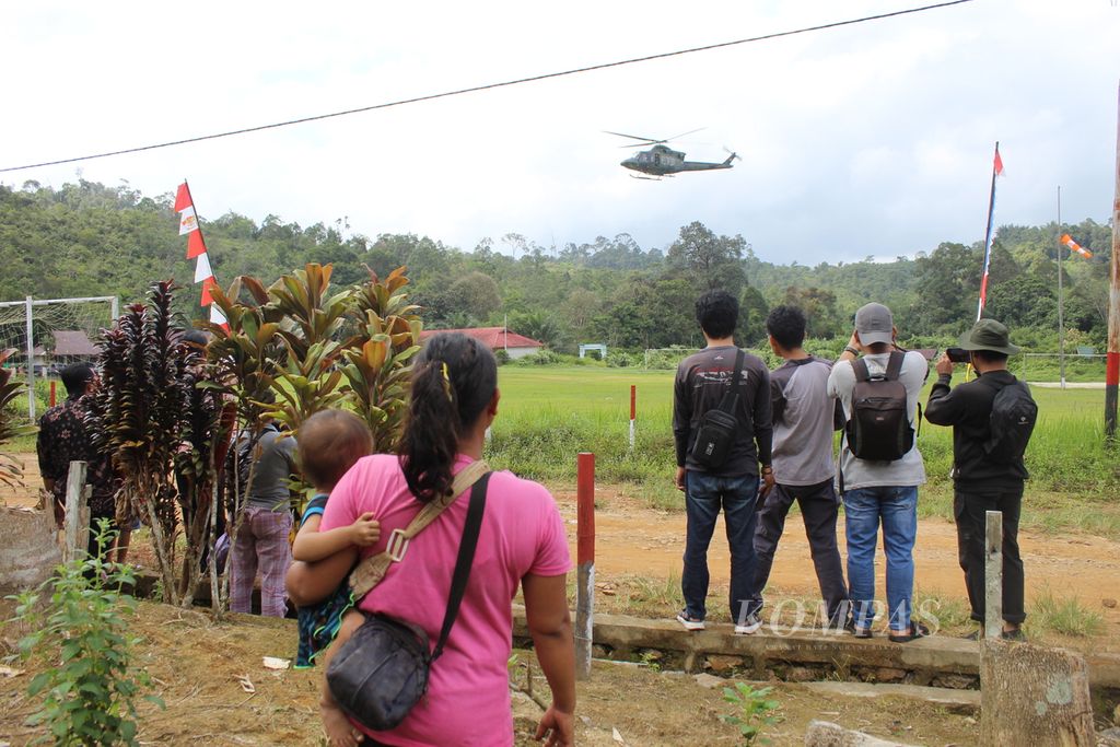 Warga Desa Kinipan menonton turunnya helikopter yang membawa rombongan Menteri Lingkungan Hidup dan Kehutanan RI Siti Nurbaya bersama Bezos Earth Fund (BEF), di Desa Kinipan, Kabupaten Lamandau, Kalteng, Sabtu (7/9/2024).