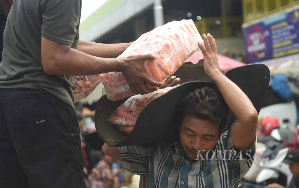 Pekerja membawa wortel yang baru tiba di Pasar Keputran Utara, Surabaya, Jawa Timur, Rabu (14/2/2024). Saat hari pencoblosan Pemilu 2024, aktivitas pasar tetap berjalan normal.  