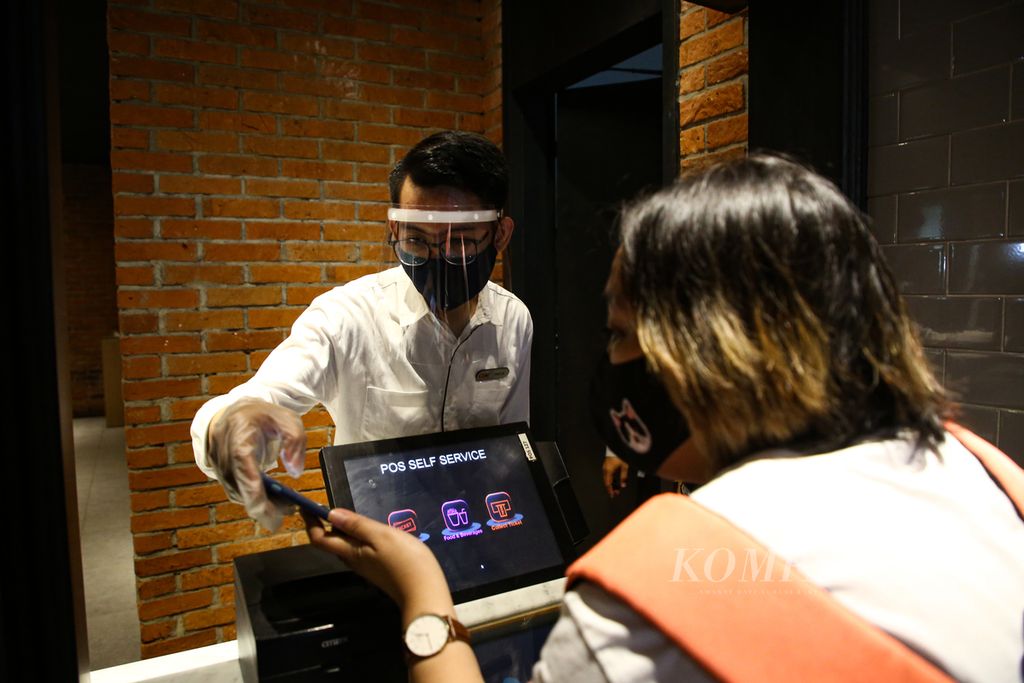 Petugas membantu pengujung yang membeli tiket secara daring di bioskop CGV di Grand Indonesia Mal, Jakarta Pusat, yang kembali dibuka untuk umum, Rabu (21/10/2020). 