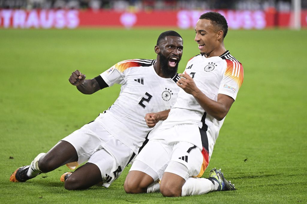 Pemain Jerman, Jamie Leweling (kanan), bersama rekannya, Antonio Ruediger, merayakan golnya ke gawang Belanda pada penyisihan Grup A3 Liga Nasional UEFA di Stadion Allianz Arena, Muenchen, Selasa (15/10/2024) dini hari WIB. Jerman menang 1-0 pada laga itu.