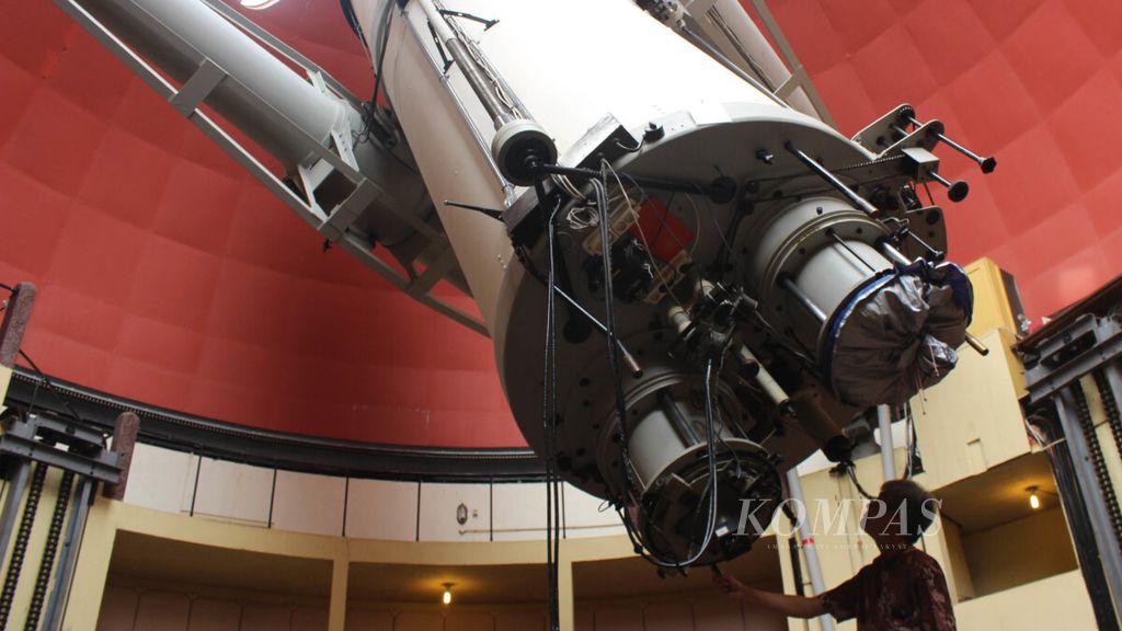 Peneliti Observatorium Bosscha Denny Mandey menggerakkan teleskop refractor ganda Zeiss di Lembang, Kabupaten Bandung Barat, Jawa Barat, Sabtu (1/12/2018). Teleskop berusia 90 tahun tersebut telah digunakan untuk 12.000 pengamatan pada lebih dari 3.000 bintang.