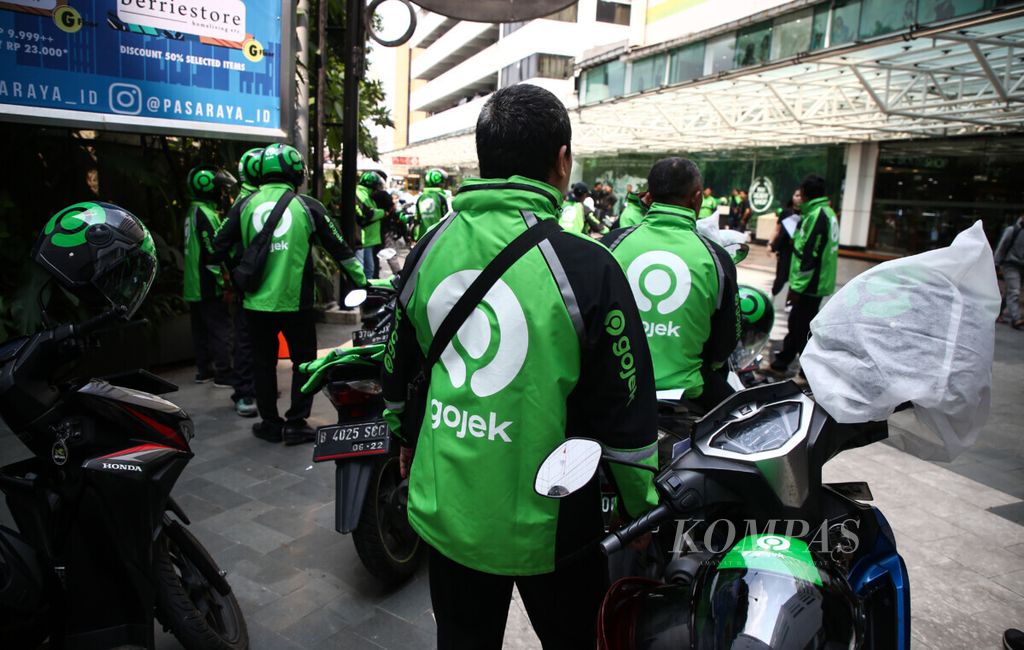 Gojek drivers wear jackets and helmets with the new logo during the Gojek logo change (<i>rebranding</i>) event with Gojek Group founder and CEO Nadiem Makarim in Jakarta, Monday (22/7/2019). The launch of this logo marks GoJek's evolution from a ride-hailing service to an integrated ecosystem that moves people, goods and money.