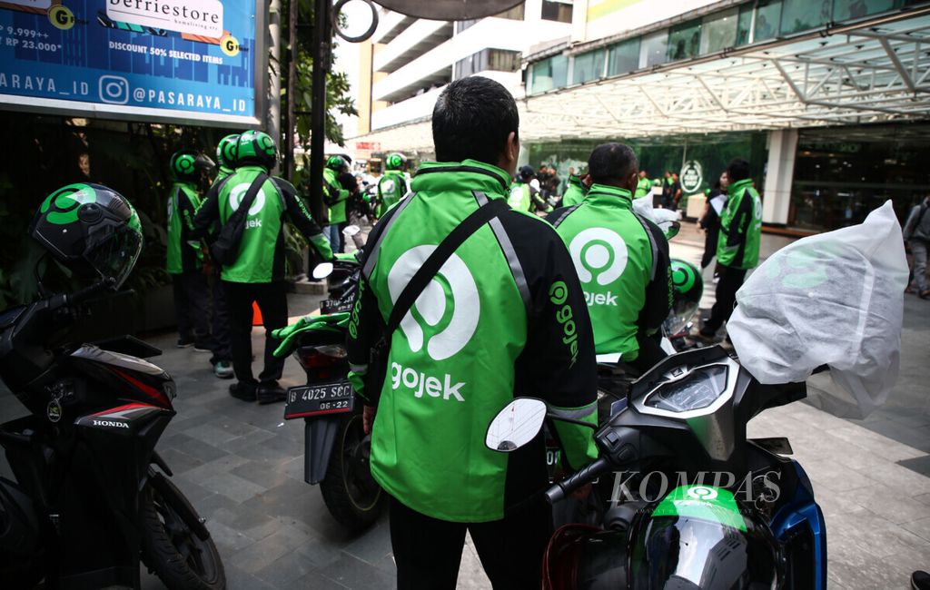 Pengemudi Gojek mengenakan jaket dan helm berlogo baru saat acara pergantian logo (<i>rebranding</i>) Gojek bersama pendiri dan CEO Gojek Grup Nadiem Makarim di Jakarta, Senin (22/7/2019). Peluncuran logo ini menandai evolusi gojek dari layanan <i>ride-hailing </i>menjadi sebuah ekosistem terintegrasi yang menggerakkan orang, barang dan uang.