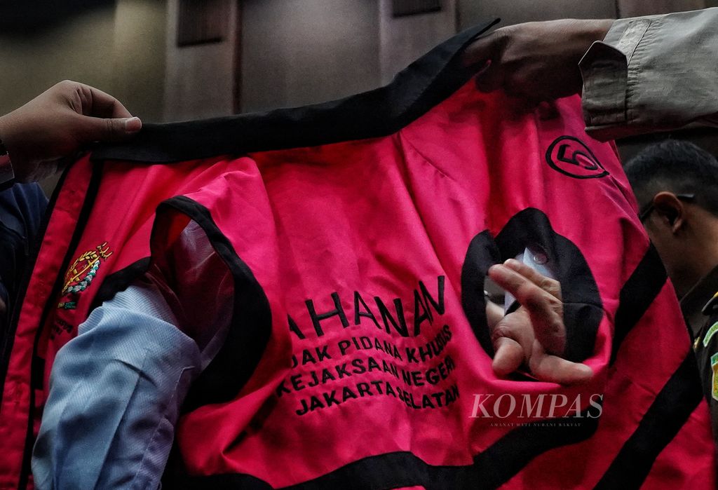 Tangan bekas Menteri Komunikasi dan Informatika Johnny G Plate masuk ke dalam lubang rompi tahanan yang dikenakannya seusai sidang kasus korupsi penyediaan BTS 4G Bakti dengan agenda tanggapan jaksa penuntut umum di Pengadilan Tindak Pidana Korupsi Jakarta, Senin (11/7/2023). 
