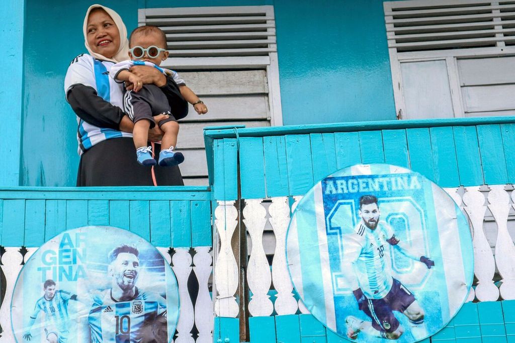 Foto pada 11 Juni 2023 menampilkan Murni, seorang<i> fans</i> Lionel Messi, warga Desa Karama, Polewali Mandar, Sulawesi Barat, menggendong cucunya bernama Muhammad Messi Pramudana. 
