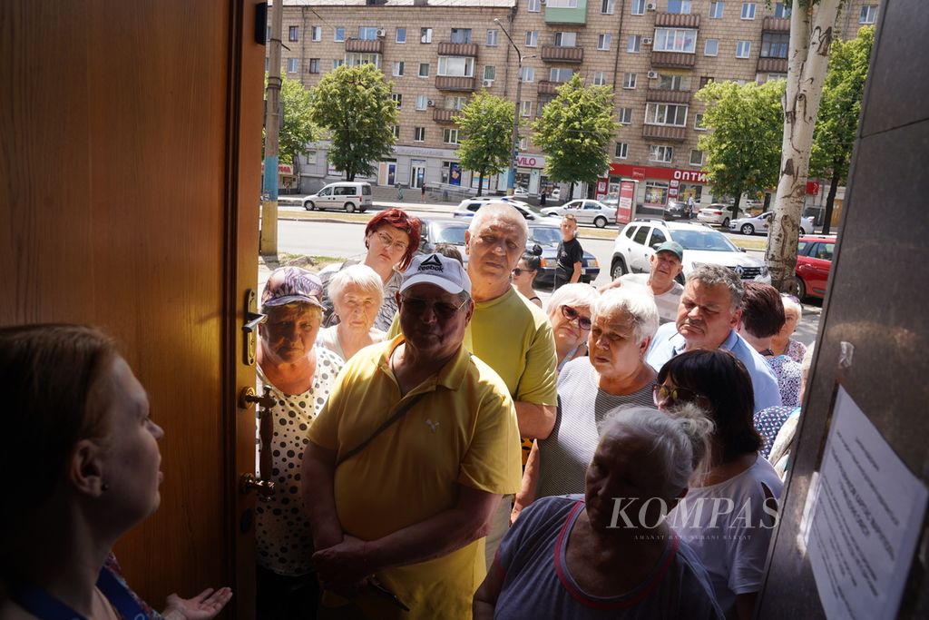 Pengungsi mengantre untuk mendapatkan bantuan dari organisasi Charitas Mariupol di Zaporizhia, sekitar 650 kilometer tenggara Kyiv, Ukraina, Selasa (21/6/2022). Akibat serangan Rusia ke Ukraina, banyak warga dari sejumlah kota mengungsi ke Zaporizhia, sebagian besar berasal dari Mariupol. 