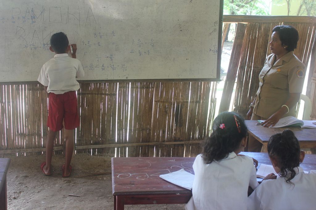 Ernawati (41), guru SD Swasta Kelapa Tinggi Kecamatan Kupang Tengah, Kabupaten Kupang, Sabtu (18/5/2019), memperhatikan salah satu siswa mengerjakan matematika, hasil pekerjaan rumah yang diberikan Ernawati.