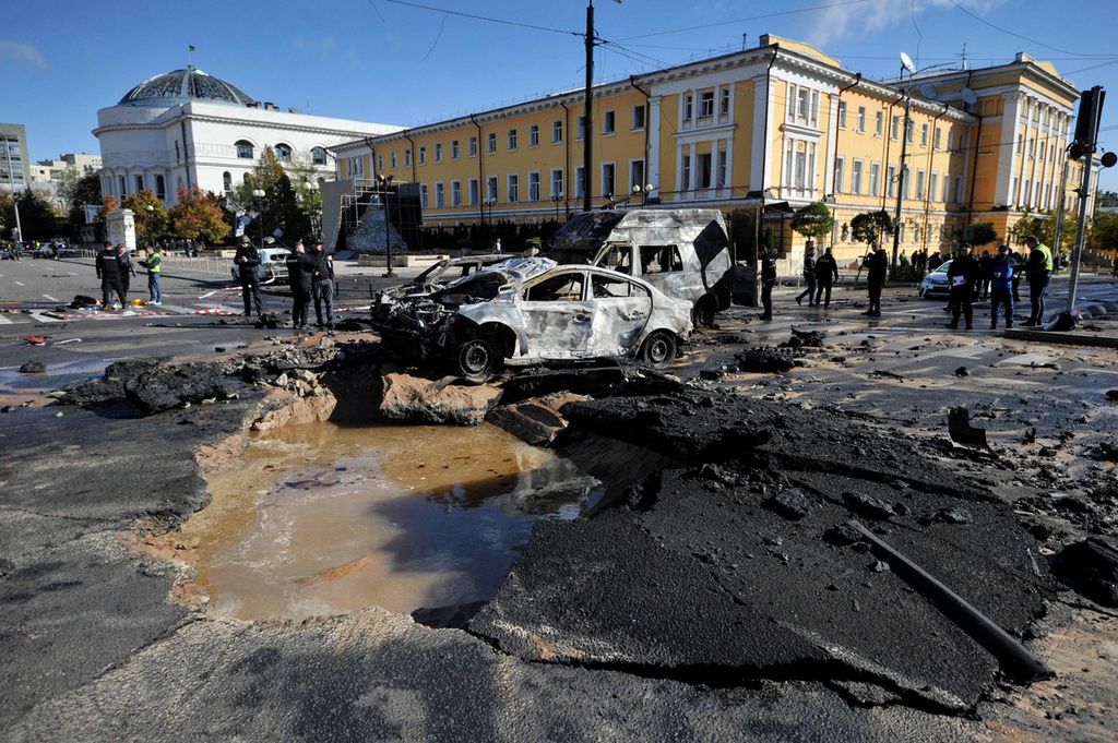 Polisi memeriksa mobil-mobil yang hancur di pusat kota Kyiv, Ukraina, setelah serangan Rusia, pada 10 Oktober 2022. 